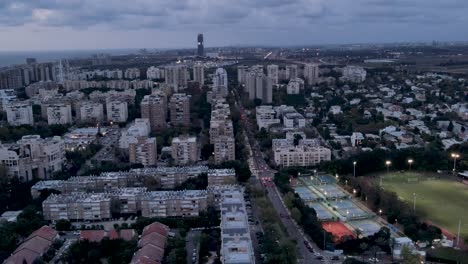 Drone-view-of-residential-buildings-and-highways-around-Hoofien-Street-at-night-in-the-city-of-Tel-Aviv,-Israel