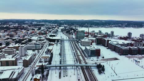 Aerial-view-of-trains-at-the-railway-station-in-Jyvaskyla,-winter-sunset-in-Finland