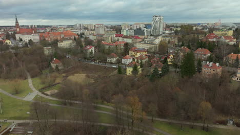 Vista-Aérea-Del-Casco-Antiguo-De-Olsztyn,-Arquitectura-Histórica,-Agujas,-Techos-Rojos,-Horizonte-Moderno,-Vegetación-Urbana,-Contraste-De-Desarrollo