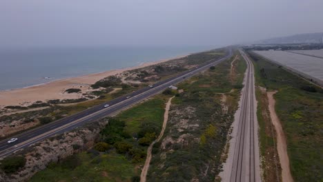Magadim-rail-track,-Coastal-railway,-and-highway-parallel-to-a-sandy-beach