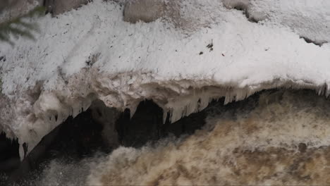 Primer-Plano-De-Las-Formaciones-De-Hielo-Invernal-A-Lo-Largo-Del-Borde-De-Un-Río-Que-Fluye-Rápidamente