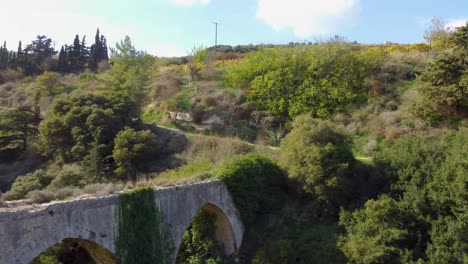 Ancient-Stone-Aqueduct-in-Crete:-Aerial-View-of-a-Historic-Structure-Spanning-a-Verdant-Valley
