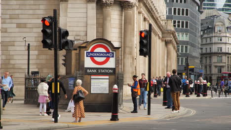 Bank-Station's-underground-entrance-near-the-Bank-of-England,-featuring-bustling-pedestrian-activity-and-traffic-in-motion