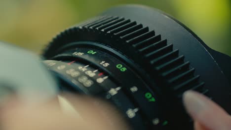 close-up-of-old-retro-vintage-film-camera-while-a-female-hand-turning-the-focus-wheel