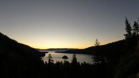 A-timelapse-video-showcasing-a-stunning-sunset-over-Emerald-Bay-in-South-Lake-Tahoe,-California-as-the-water-shimmers-as-the-sun-dips-below-the-horizon,-casting-vibrant-hues-across-the-sky