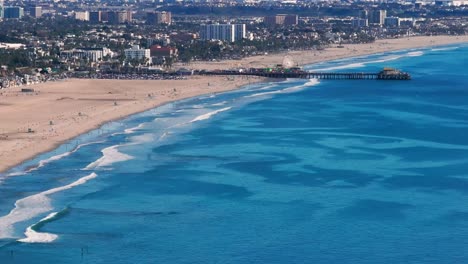 Toma-Aérea-De-Un-Dron-Mirando-Las-Olas-Rompiendo-En-La-Playa-De-Santa-Mónica