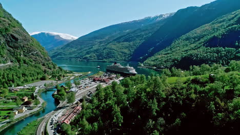 Aerial-Flam-village-Norway-fjord-cruise-ship-at-shore-mountains-valley