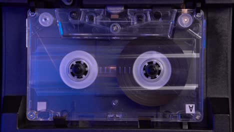 Transparent-Audio-Cassette-Tape-Playing-From-Start-in-Vintage-Deck-Player,-Close-Up