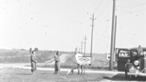 Frauen-Und-Männer-Stehen-Neben-Einem-Hund-An-Einem-Straßenrand-Im-Freien-In-Den-1930er-Jahren
