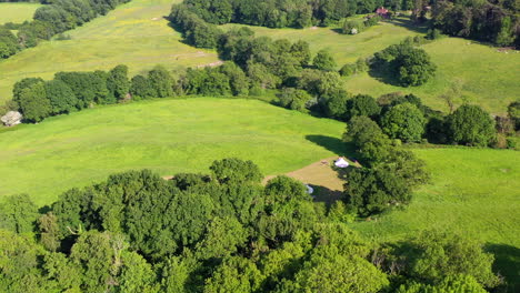 Aerial-panning-reveal-Great-Oaks-Glamping-Sunny-day-UK-4K