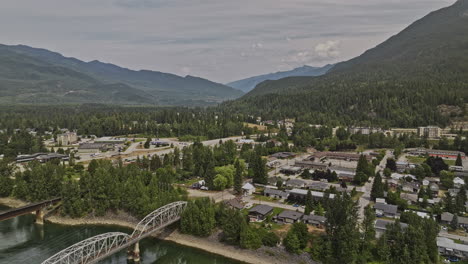 Revelstoke-BC-Canada-Aerial-v2-drone-flyover-Columbia-river-capturing-picturesque-townscape,-bridges-crossings,-highway-route-and-forested-mountain-landscape---Shot-with-Mavic-3-Pro-Cine---July-2023