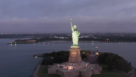 Drohne-Umkreist-Die-Freiheitsstatue-Am-Frühen-Morgen,-Luftaufnahme-Der-Statue-In-New-York-City,-Drohnenaufnahme-4k