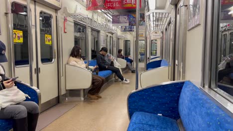 Pasajeros-Dentro-Del-Tren-Subterráneo-En-Movimiento-En-Tokio,-Japón