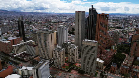 Toma-Aérea-De-Seguimiento-De-Un-Rascacielos-En-El-Centro-De-Bogotá,-Colombia-Parcialmente-Soleada.