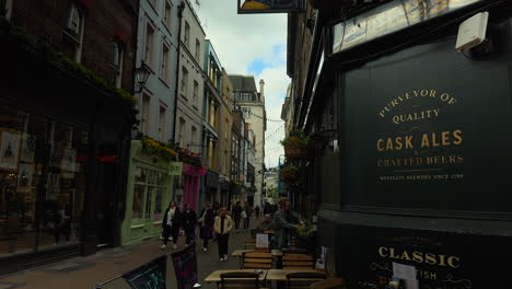 Tilt-down-from-pub-sign-to-street,-Shakespeare's-Head-pub,-Carnaby-Street,-London,-Medium-Shot,-Day,-Exterior