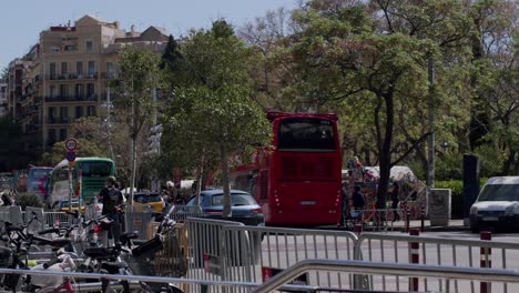 Red-Barcelona-city-tour-bus-on-a-sunny-day-with-tourists-and-city-life