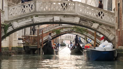 Gondola-ride-in-Venice-Canal,-boats-passing-under-bridge,-Italy