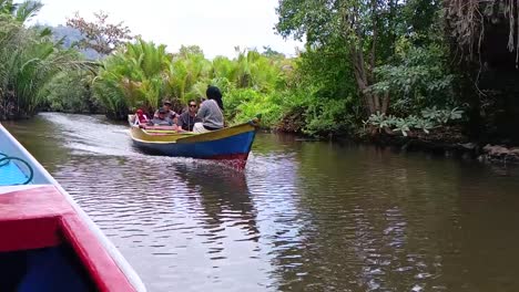 Tourists-driving-a-traditional-boat-visit-the-geological-site-in-Ramang-Ramang-village,-Maros,-South-Sulawesi