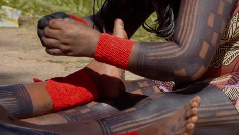 Amazonian-Tribesperson-Hand-stitching-Orange-Cuffs,-Slow-Motion