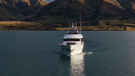 Frontal-pullback-of-Yacht-tour-driving-across-scenic-mountains-glowing-from-sunlight