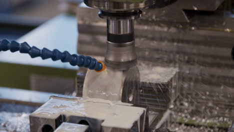 A-spinning-CNC-machine-cutting-a-wet-cilinder-of-aluminium