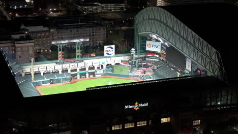Aerial-view-looking-inside-the-iIlluminated-Minute-maid-park,-night-in-Houston,-USA