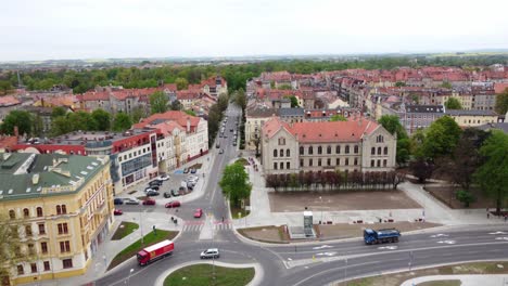 Luftaufnahme-Von-Autos,-Die-Auf-Der-Straße-Vor-Dem-Komplex-Der-Wirtschaftsschule-In-Legnica,-Polen-Fahren