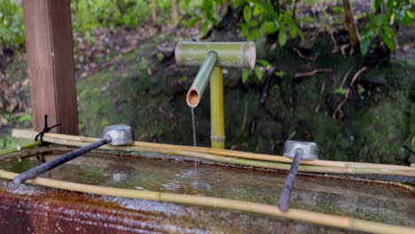 Tsukubai---Water-Supply-Through-Bamboo-Pipe-With-Ladles-At-Entrance-Of-Konchi-in-Temple-In-Kyoto,-Japan
