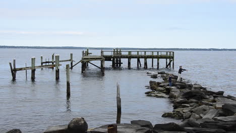 Rocky-Point-Park-man-and-son-fishing-by-destroyed-dock-on-rocky-shore-on-a-calm-ocean-day