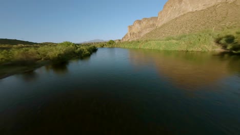 Aerial-FPV-Flying-And-Sweeping-With-Dramatic-Turns-Over-Salt-River-With-View-Of-Surrounding-Mountains,-Desert-Shrubs-In-central-Arizona