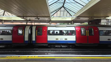 Jubilee-Line-Train-With-Passengers-Leaving-At-Finchley-Road-Tube-Station-In-London,-United-Kingdom