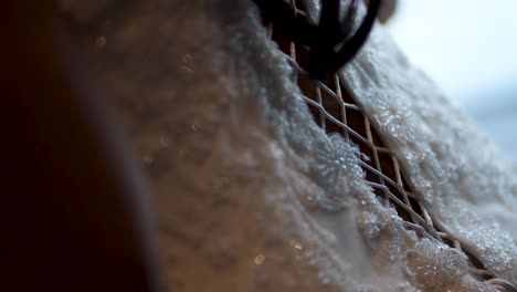 A-detailed-close-up-shot-captures-the-intricate-design-of-a-bride's-wedding-gown
