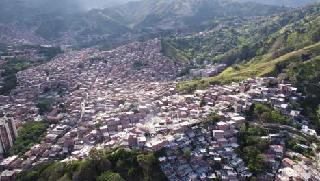 Favela-Iluminada-Por-El-Sol-De-La-Comuna-13-Que-Se-Extiende-Sobre-Las-Colinas-De-Medellín,-Colombia---Vista-Aérea