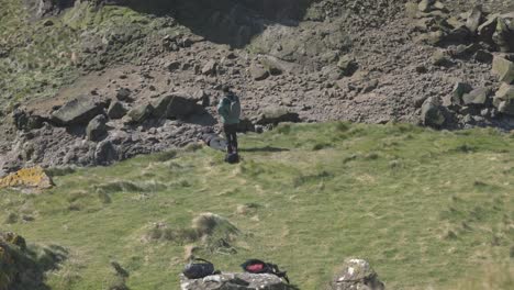 Hand-held-shot-of-a-woman-lying-over-the-cliff-edge-at-Lunga-photographing-puffins