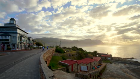 View-from-Hermanus-coastline-of-golden-sunrise-god-rays-breaking-through-clouds
