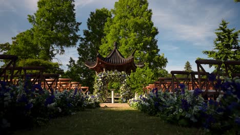 A-view-of-a-beautiful-wedding-reception-set-up-in-a-lush-garden,-captured-in-the-soft-light-of-a-lovely-day