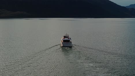 Drone-Asciende-Por-Encima-Del-Recorrido-En-Yate-En-El-Lago-Wakatipu-Al-Atardecer