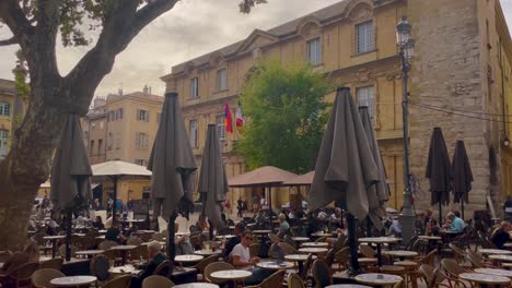 Tourist-sitting-at-cozy-outdoor-cafe-in-Aix-en-Provence,-handheld-view