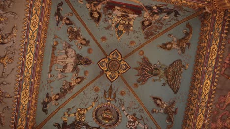 Roatating-shot-of-the-colorful-religious-paintings-and-carvings-on-the-interior-of-the-archway-of-Patuxai-Victory-Monument-in-the-center-of-Vientiane,-Laos