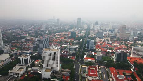 The-bustling-streets-in-the-heart-of-Surabaya,-the-second-largest-city-in-Indonesia,-signify-rapid-economic-growth-with-tall-buildings-soaring-amidst-densely-populated-urban-landscape