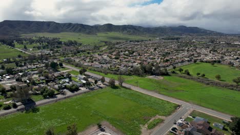 A-stunning-aerial-view-of-Murrieta,-California,-showcasing-vast-green-spaces,-open-landscapes,-picturesque-mountain-views,-and-scattered-suburban-homes,-creating-a-serene-and-scenic-setting