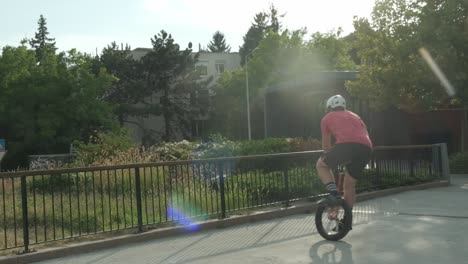 Un-Hombre-Adulto-Enérgico-Balanceándose-Y-Saltando-En-Un-Monociclo-En-Un-Jardín-Urbano