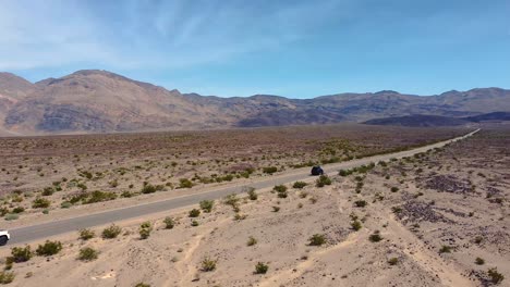 Vehículos-Circulando-Por-La-Carretera-A-Través-Del-Desierto-Seco-En-El-Valle-De-La-Muerte,-California