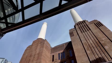 An-upward-gaze-at-the-iconic-towers-of-Battersea-Power-Station-in-London,-embodying-the-concept-of-architectural-grandeur-and-urban-regeneration