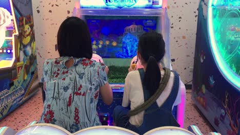 Madre-E-Hija-Asiáticas-Pasan-Tiempo-Juntas-Jugando-Juegos-De-Arcade-En-El-Centro-De-Juegos-De-Un-Centro-Comercial