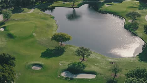 Ein-Teich,-Sandgruben-Und-Bäume,-Die-Lange-Schatten-Werfen,-Sitzen-An-Einem-Sonnigen-Nachmittag-Auf-Einem-Grünen-Golfplatz-In-Florida