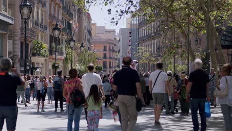 überfüllte-Straße-In-Barcelona-Mit-Fußgängern-Und-üppigen-Bäumen-An-Einem-Sonnigen-Tag