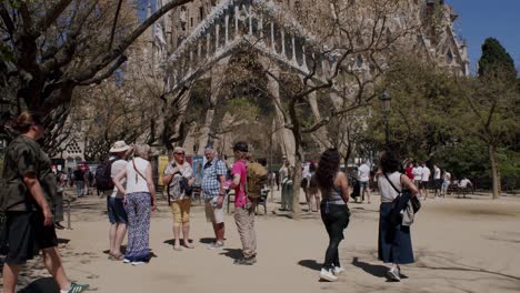 Tourists-stroll-in-front-of-the-iconic-Sagrada-Familia-on-a-sunny-day-in-Barcelona