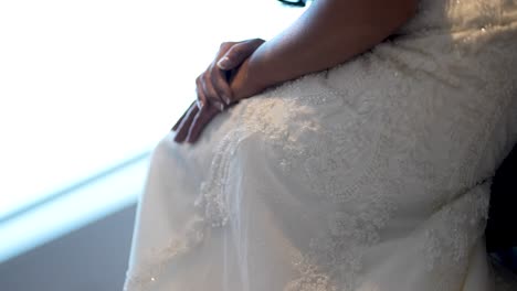 Capture-the-elegance-of-a-bride-gracefully-lifting-her-wedding-gown-while-seated