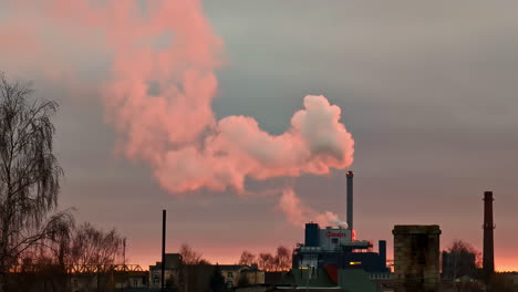 Industrial-factory-plant-blowing-out-steam-at-sunset-with-pastel-color